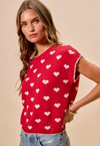 Woman wearing a red sweater with white heart patterns 