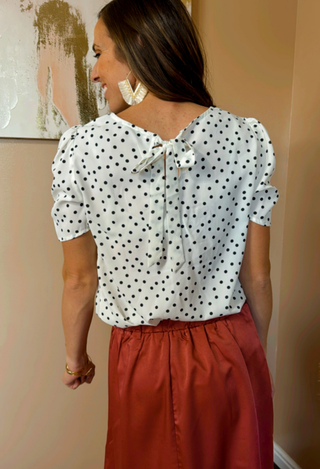 white blouse with dot print and red silk skirt
